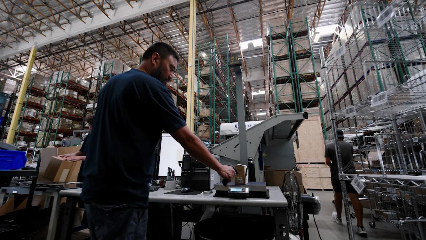 Associate preparing and labeling boxes at a packing station